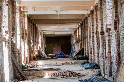 A concrete photograph of an unfinished building site, construction equipment, or partially built infrastructure that has been left incomplete, representing failed government projects