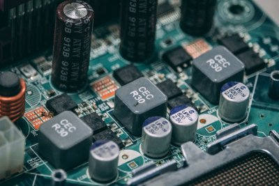 Close-up of multiple large cylindrical capacitors mounted on a circuit board with wiring and electronic components