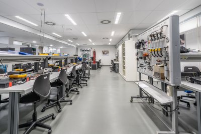 Interior of a modern laboratory or testing facility with technical equipment, computers, and engineering infrastructure typical of defence research centres