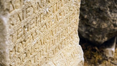 A close-up of an ancient stone tablet or monument with carved text and symbols, similar to historical legal documents from ancient civilizations